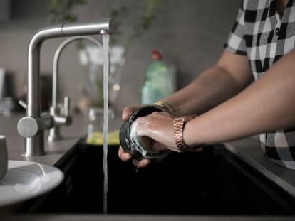 Una mujer friega un vaso en un piso de Barcelona.