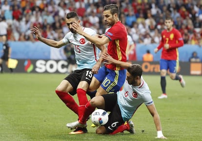 El centrocampista de la selección española Cesc Fábregas (c) disputa el balón con los turcos Hakan Calhanoglu (d) y Mehmet Topal (i).