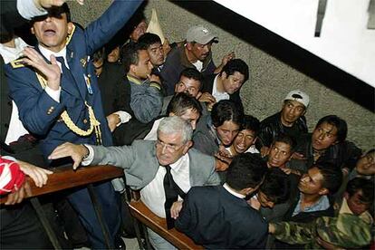 Alfredo Palacio, en el centro de la fotografía, se abre paso dentro del Parlamento de Ecuador instantes después de asumir el mando del país, en sustitución de Lucio Gutiérrez.