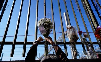 Una persona deja un ramo de flores en una de las vallas cercanas a la estación de Atocha durante el 15 aniversario de los atentados del 11-M, en Madrid.