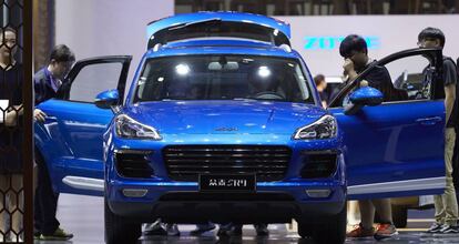 Visitantes de la feria del automóvil de Shanghái observan el coche Zotye SR9, muy parecido a un Porsche Macan. 