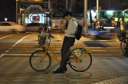 Un usuario de Youbike, junto a la estación de metro del edificio Taipower. Entre 50.000 y 60.000 desplazamientos diarios se realizan en Taipei con este sistema de alquiler. Según Vicky Yang “el éxito de esta iniciativa ha desbordado al gobierno de la ciudad".