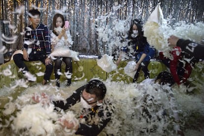 Una mujer se fotografía durante una batalla de almohadas en Pekín (China).