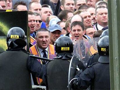 Miembros de la protestante orden de Orange son detenidos por policías antidisturbios en Drumcree, en julio de 2002.