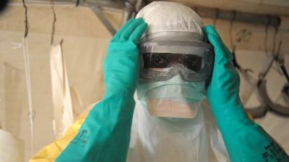 Un médico se coloca el traje de protección para entrar en la sala de aislamiento de Médicos Sin Fronteras en la región de Guekedou.
