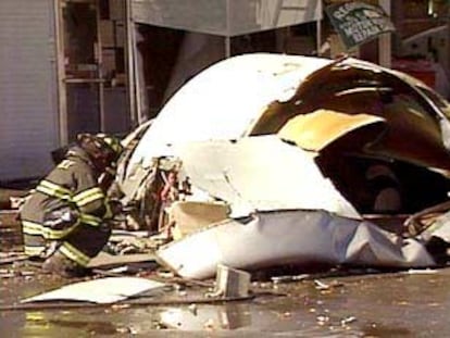 Un bombero examina los restos del fuselaje del avión siniestrado en Queens.
