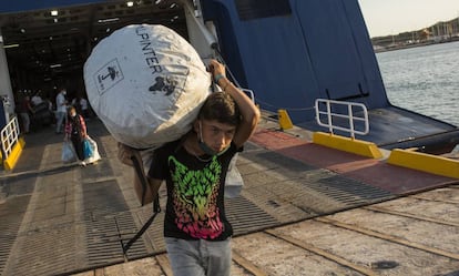Refugiados del campamento incendiado de Moria en Lesbos desembarcan en un ferry en el puerto de Lavrio para ser trasladados a otro asentamiento en la Grecia continental.