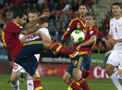 Cesc Fábregas despeja el balón en el área ante la mirada de Monreal y Ramos.