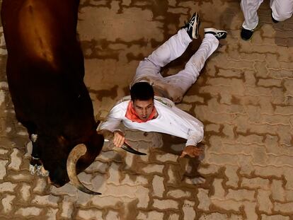 La caída de un mozo durante el sexto encierro de San Fermín, este martes en Pamplona.