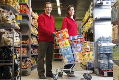 El arquitecto Xavier Sans y su esposa aparejadora, María Verdaguer, trabajando en su nuevo oficio en su supermercado.