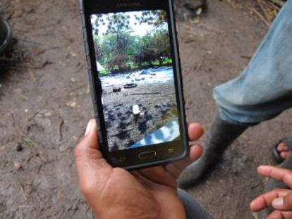 Ezequiel Welmer revisa en su teléfono las fotos de su antigua comunidad calcinada.