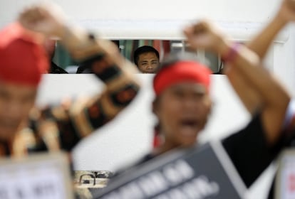Un guardia militar observa cómo los indígenas filipinos conocidos como 'Lumad' levantan los puños cerrados durante una manifestación a las afueras de la sede militar del Campo Aguinaldo en la zona metropolitana de Manila (Filipinas).