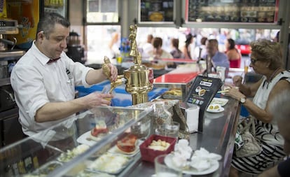 Un camarero tira una caña en un bar de Sevilla.