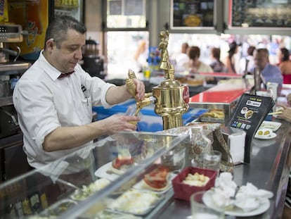 Un camarero tira una caña en un bar de Sevilla.