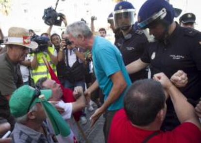 El portavoz del Sindicato Andaluz de Trabajadores (SAT), Diego Cañamero (c), habla con algunos de los jornaleros concentrados el pasado mes de agosto a las puertas de la oficina de la Caixa ubicada en la barriada de El Tejar en el Puerto de Santa María de Cádiz.