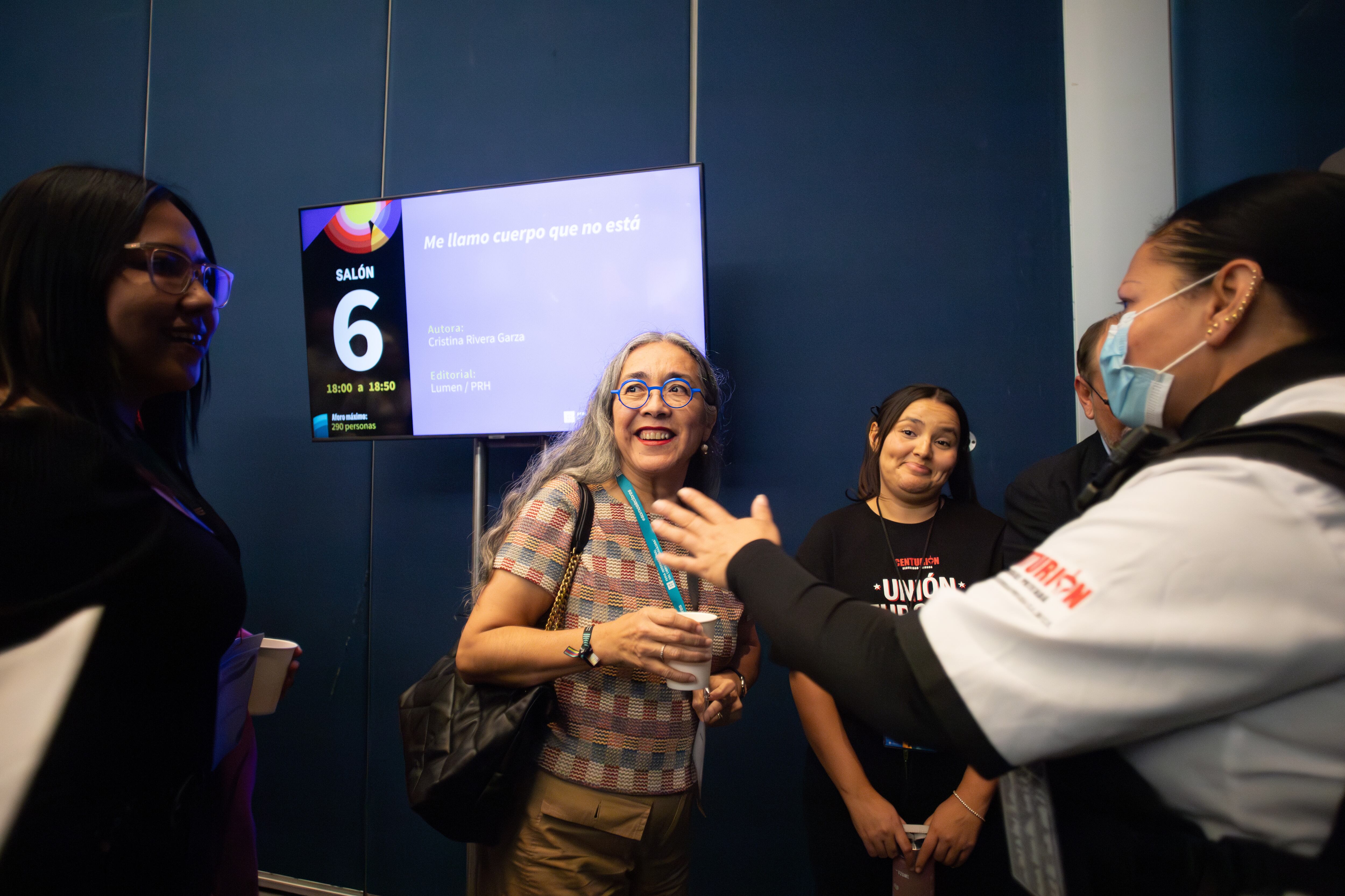 Elementos de seguridad conversan con Cristina Rivera en los pasillo de la feria. 