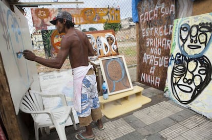 Um ateliê improvisado na cracolândia reúne quadros pintados pelo artista da foto, amparado pela frase "Faça sua estrela brilhar e não apague a minha".