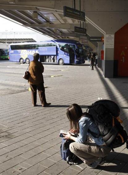 Viajeros esperan en los andenes de la estación Sur de autobuses a media tarde de ayer.