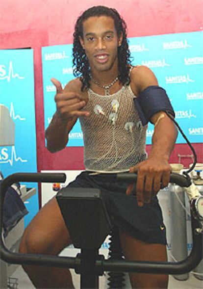 Ronaldinho saluda levantando el pulgar y el meñique.