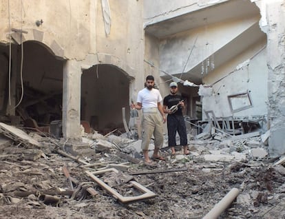 Dos hombres sujetan obuses en una casa destruída en el barrio de Bab Todmor en Homs, el 12 de julio de 2012.