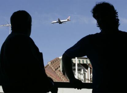 Vecinos de San Fernando de Henares (Madrid) contemplan el vuelo de un avión.