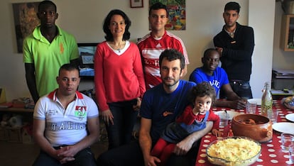 Madrid, España, 4 de mayo de 2013. Cuca Sánchez (3i) y su pareja Roberto Borda (en el centro con su hija) forman parte de una red humanitaria que ayuda a inmigrantes irregulares y que reclamaba entonces al Gobierno el cambio de un artículo del anteproyecto de reforma del Código Penal que criminalizaba la ayuda a sin papeles. En la imagen, la pareja posa con tres inmigrantes que en mayo vivían con ellos y con otros tres que lo hicieron en el pasado.