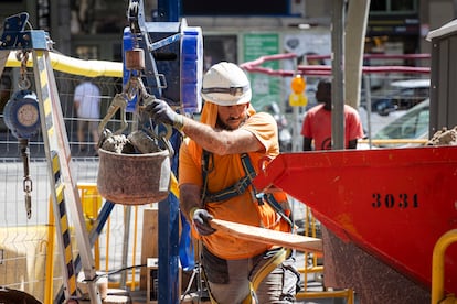 Un trabajador se protege del calor en una obra en la Calle Sepúlveda de Barcelona, el pasado martes.
