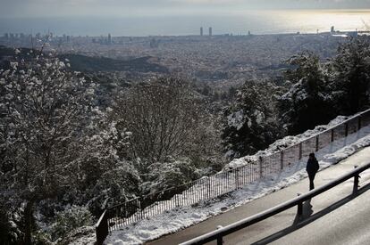 Una persona camina por una carretera en la sierra de Collserola vista desde el Tibidabo en Barcelona.