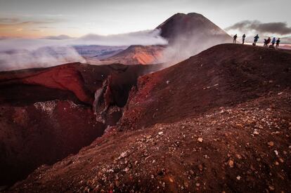 Cráter rojo característico del macizo de Tongariro, en Nueva Zelanda, con el monte Ngauruhoe al fondo.