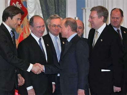 Vladímir Putin (derecha) estrecha la mano del ministro de Finanzas austriaco, en presencia de Rato (entre ellos).