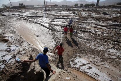 Vecinos caminan por una calle afectada por las inundaciones en Diego de Almagro, en el desierto de Atacama, al norte de Chile.