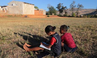 Dos niñas hacen los deberes en el campo, en Madagascar.