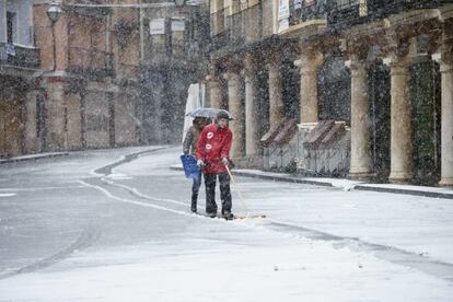 Dos personas caminan por una calle de Teruel bajo una intensa nevada.