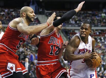 Rodney Stuckey, de los Detroit Pistons, defendido por Carlos Boozer y Kirk Hinrich, de Chicago