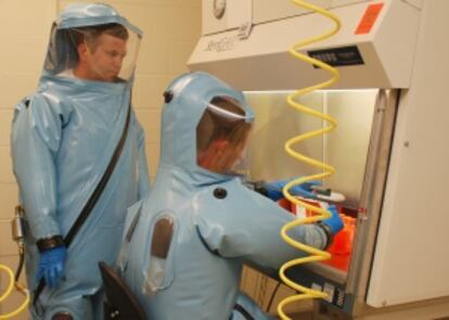 Gene Olinger, de pie, en un laboratorio militar de alta seguridad de Fort Detrick (EEUU).