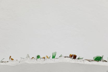 Otro pueblo ineludible es Olvera; la estampa, a bulto, se parece no poco a la de Arcos, con la iglesia y el castillo remansando la crecida de viviendas. En la imagen, piezas de vidrio incrustadas en la pared de una casa en Olvera.