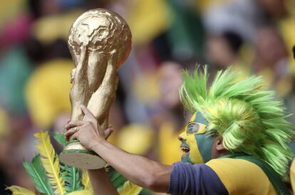 Torcedor do Brasil vai à partida preparado com a taça da Copa.