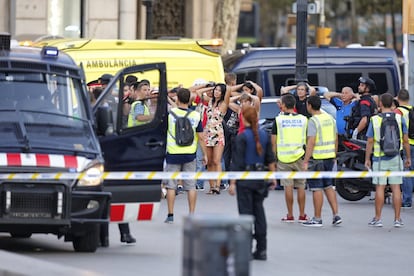 Un grupo de personas es dirigido por la policía tras el desalojo de un restaurante.