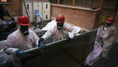 Unos operarios retiran una pizarra con amianto de una escuela pública del área metropolitana de Barcelona
