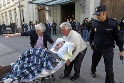 Los padres de Meño mueven a su hijo, ayer delante de la sede del Tribunal Supremo.