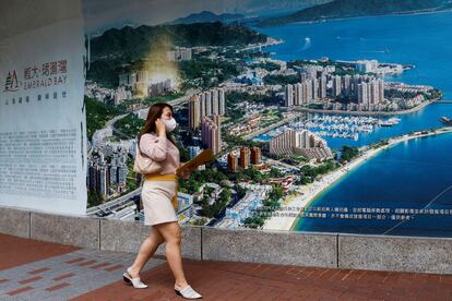 Una mujer pasa ante el anuncio de una promoción de viviendas construidas por Evergrande en Hong Kong