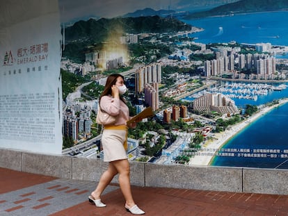 Una mujer pasa ante el anuncio de una promoción de viviendas construidas por Evergrande en Hong Kong