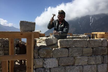 This April 5, 2016 photo shows a Nepali builder at a construction site at a mountain viewing point on the outskirts of Namche Bazaar, Nepal. A trek to Everest Base Camp along mountain paths hugging it's deep gorges offers renewal and a test of mental and physical limits. A trek to Everest Base Camp along mountain paths that hug deep gorges offers renewal and a test of mental and physical limits. Along the way there are sore knees and altitude sickness, but the spectacular landscapes, friendly villagers and moments of tranquility make the journey an unforgettable experience. (AP Photo/Karin Laub)