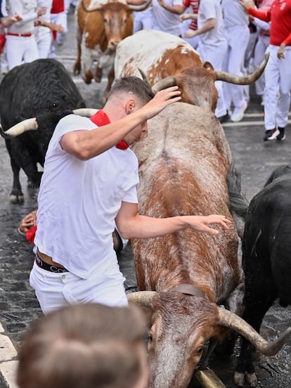 Een renner passeert de stieren van de Fuente Ymbro-ranch, deze maandag tijdens de eerste stierenrennen van San Fermín.
