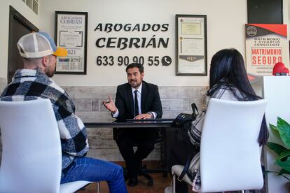 Alberto García Cebrián habla con unos clientes que han ido al despacho a informarse después de una separación en Leganés, Madrid.