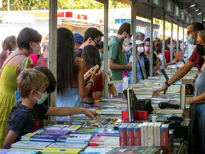 Varios niños eligen cómics en la Feria del Libro de Madrid.