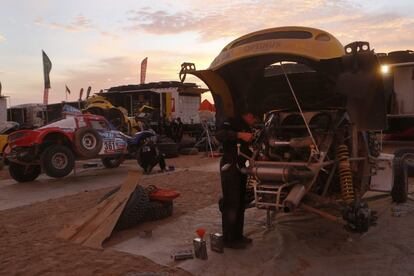 Los mecánicos revisan los coches en el campamento del Dakar tras la etapa.