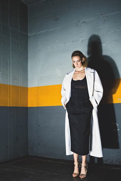 Abrigo blanco, top con transparencias y falda lápiz de cintura alta, todo de MAX MARA.