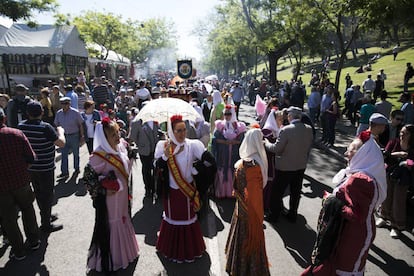 Una mujer sostiene un parasol vestida de chulapa junto a otras compañeras.