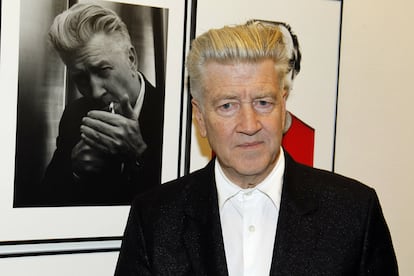 El cineasta David Lynch posa frente a uno de los retratos realizados por Karl Lagarfeld durante la inauguración de la exposición en París.